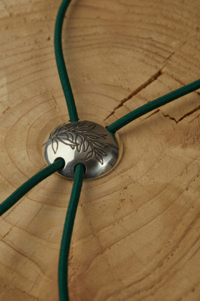 The ultimate unisex accessory has been the product of an amazing collaboration between the ROAD x Contemporia. The nature motif  is 3D carved in sterling silver. The green cord constitutes the liaison between the natural and hard elements. The medallion brings us back to the days when nobles wore the symbols dedicated to their trait. The diameter of the neck piece is 3cm.