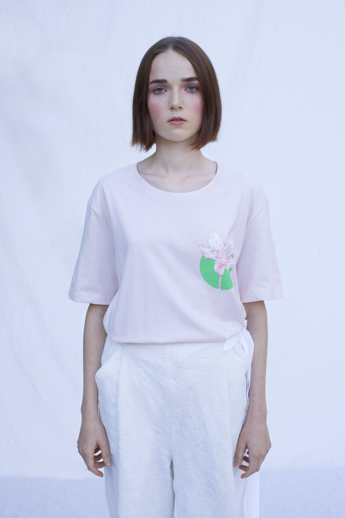 Playful and feminine, this T-shirt has been designed by Stella Stanley with an added beautiful floral motif designed by the ROAD team. Crafted out in 100% cotton with a round neck collar, available in 2 colors, both symbolizing the brightness of the summer days, bringing us in touch with nature. This particular one is a soft pink color.