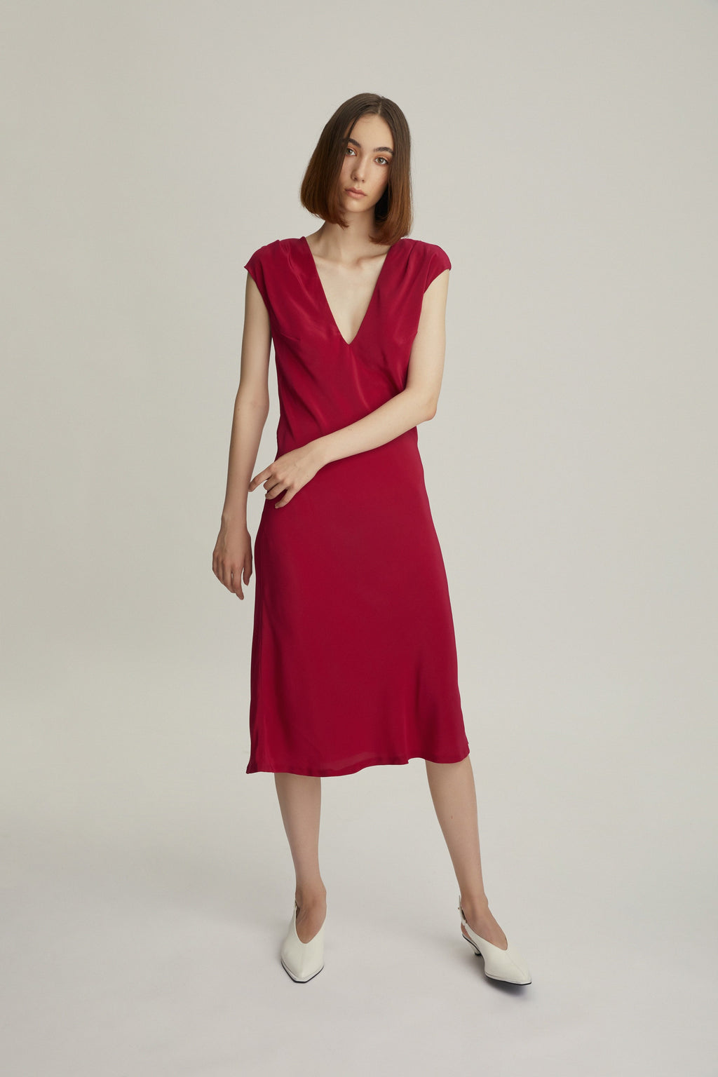 The Popping Pink Silk dress is a lightweight, slip-on style that slightly flares towards the hem for a clean silhouette.   Made from fluid 100% silk with a smooth quality, this slip dress is designed with an elegant deep V-neck.The twisted back detail was added as a statement to a polished look. 