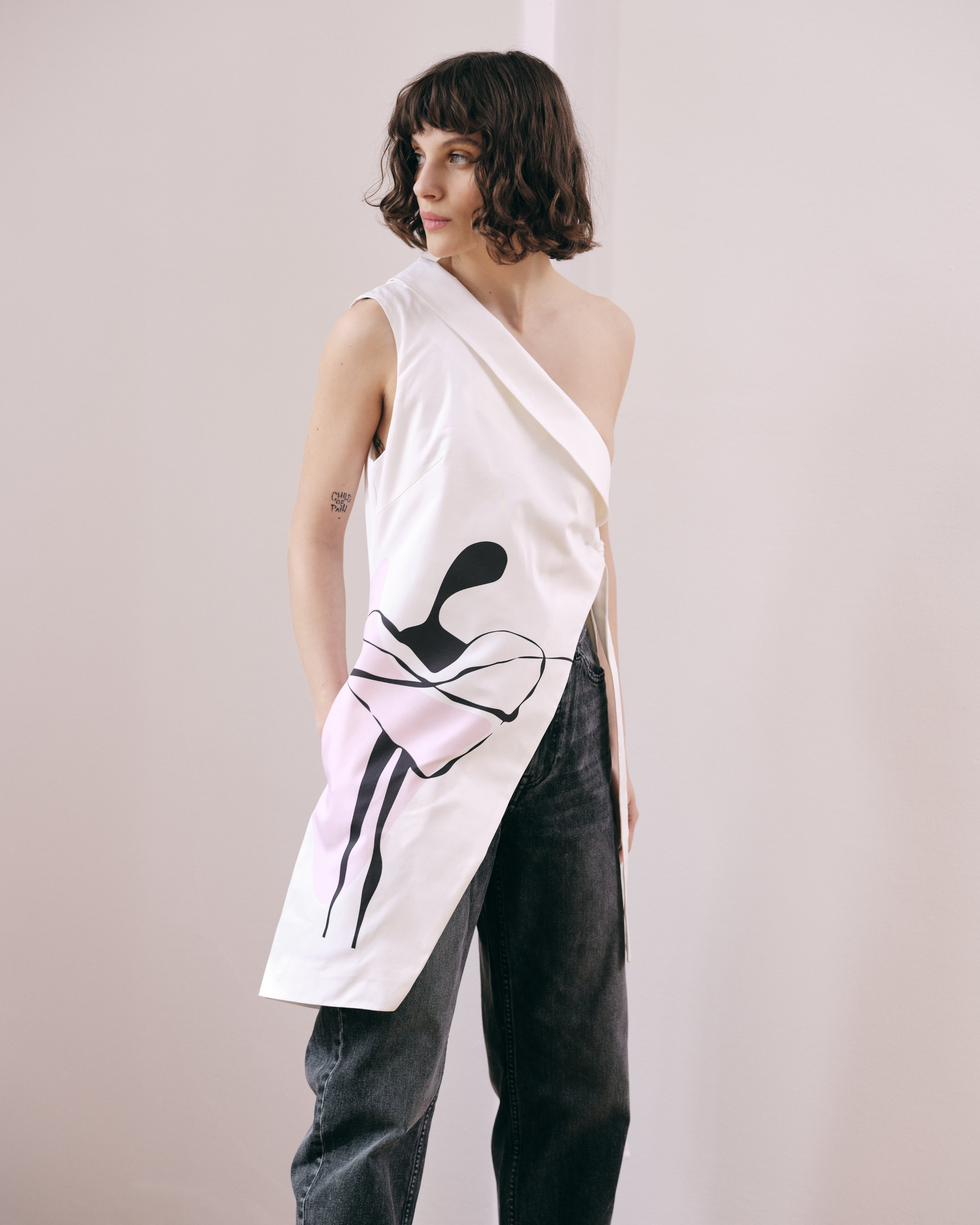 VERSATILE, adjective, able to adapt or be adapted to many different functions or activities.  Asymmetrical vest with side seam pocket on the right side. It features a one-shoulder design and tied on the left side. Illustration drawn by Madalina Marinescu Ford. Made in 100% cotton.